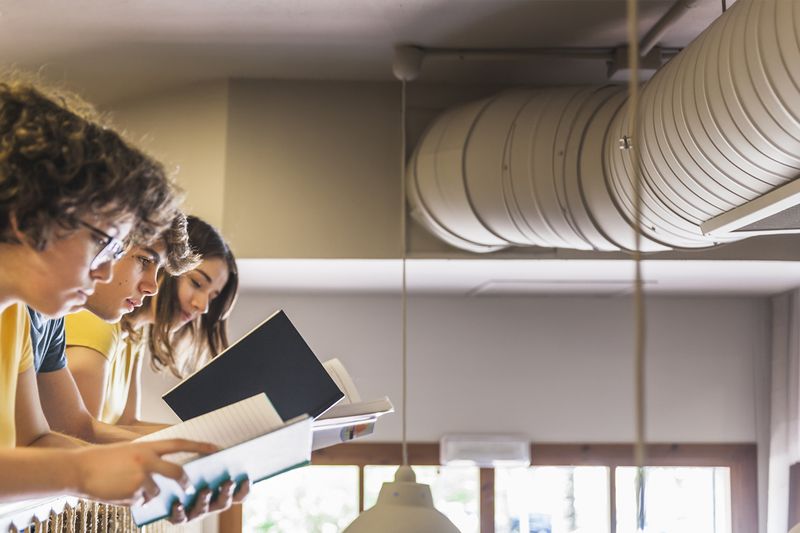 Réseau de gaines de ventilation apparent au plafond d'une pièce de vie